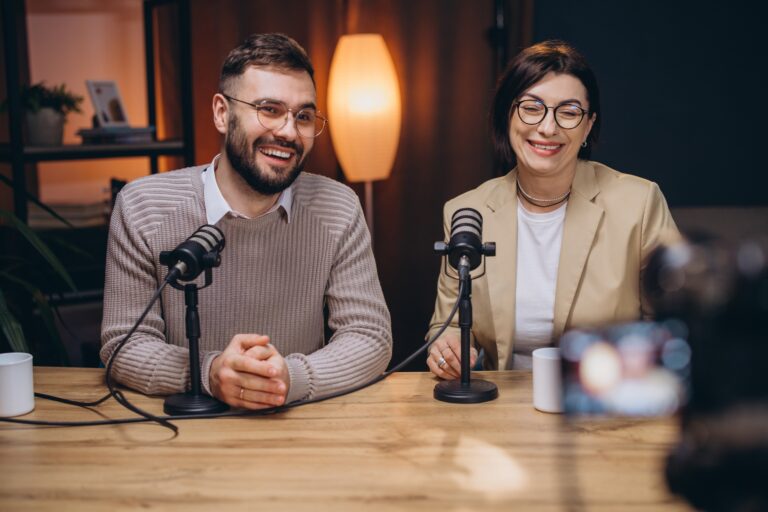 Two happy podcasters, a man and a woman, are recording a new podcast episode in professional studio